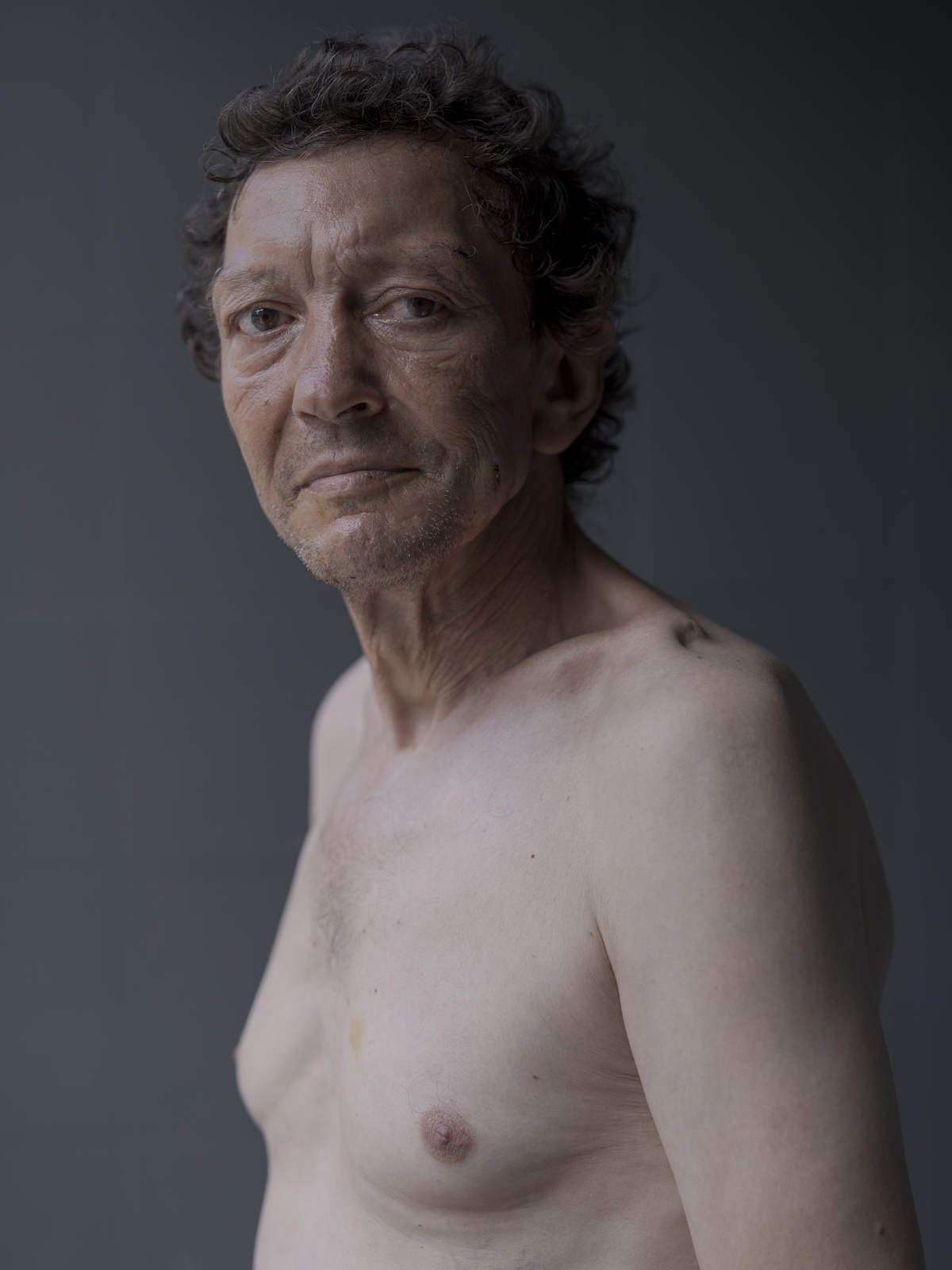 Retrato de hombre mayor de perfil con torso desnudo, luz suave