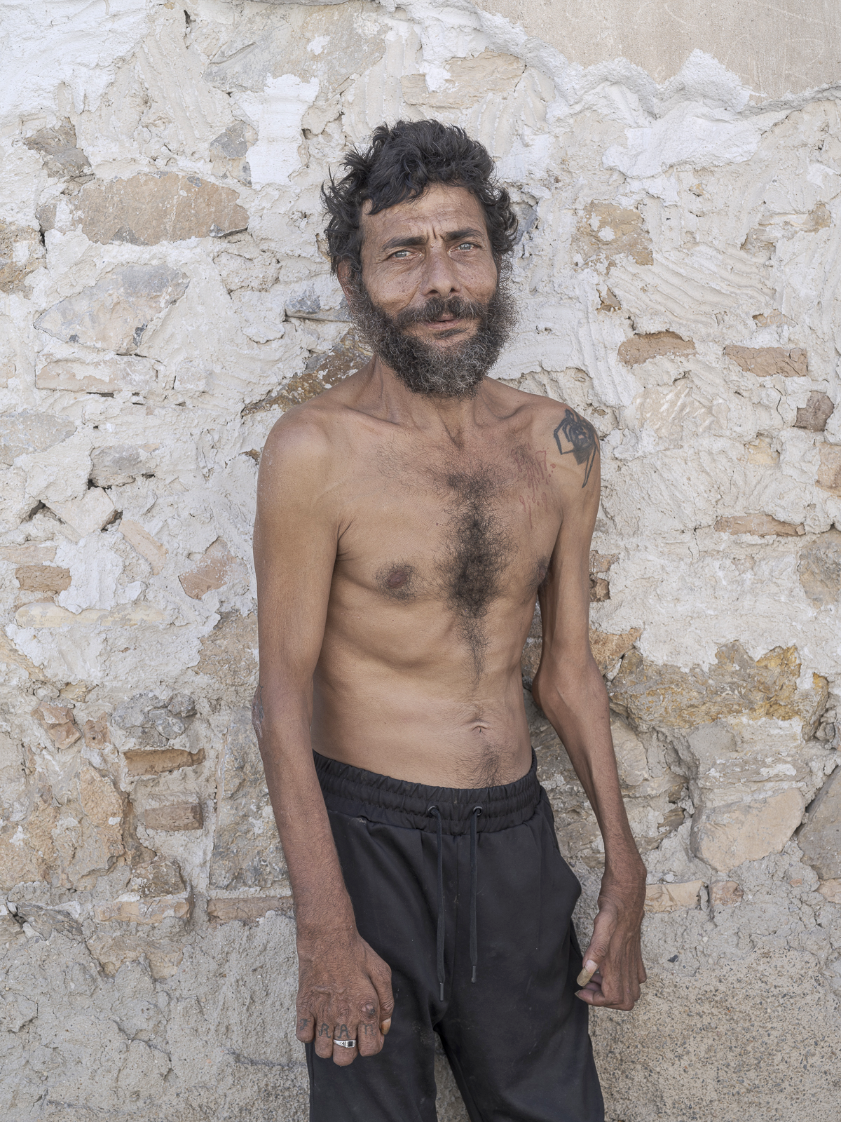 Hombre posando con el torso denudo en la calle